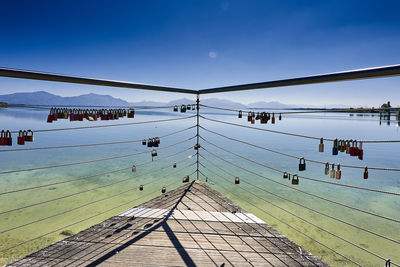 Pier over sea against clear blue sky