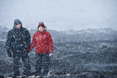 Couple walking through snowstorm in iceland