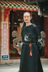Portrait of young woman standing in city