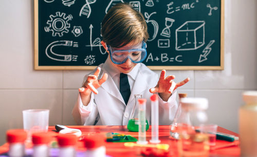 Cute boy examining chemical in classroom