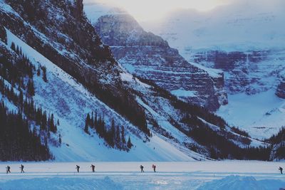 Hikers skiing on snow field at lake louise