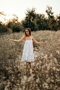 Full length of woman standing on field against sky