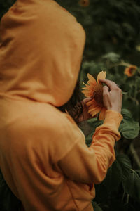 Close-up of man with orange flower