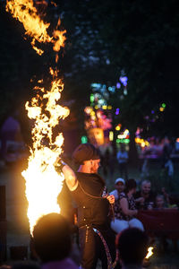 Group of people on fire in city at night