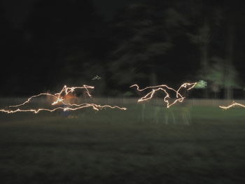 Close-up of illuminated lighting against sky at night