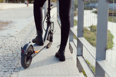 Low section of woman with push scooter