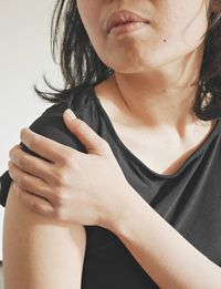 Close-up of woman with hand on white background