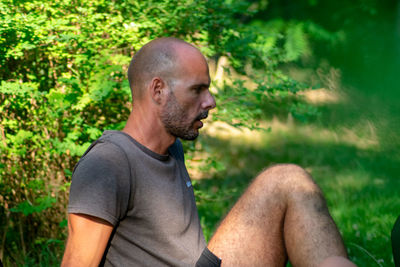 Side view of young man sitting outdoors