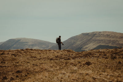 Man standing on mountain against clear sky