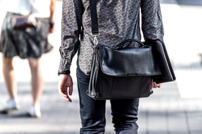 Midsection of man walking on street