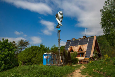 Street light by house against sky