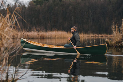 Side view of man boating in lake