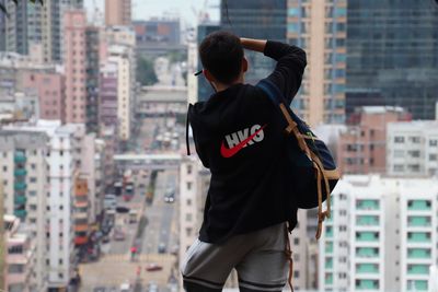 Rear view of man standing against buildings in city