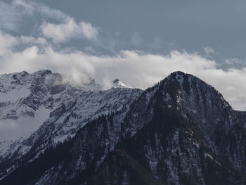 Low angle view of snowcapped mountains against sky