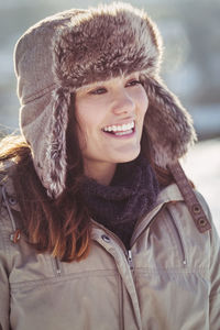 Happy woman looking away while standing outdoors