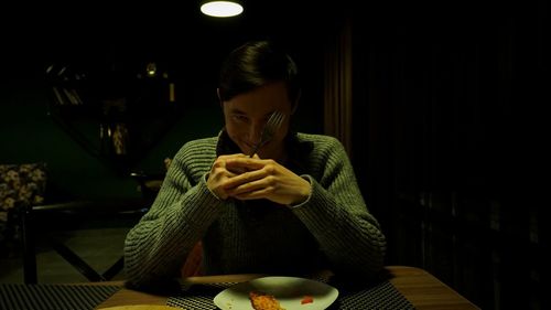 Young woman sitting on table at restaurant