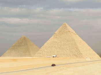 View of pyramids against cloudy sky