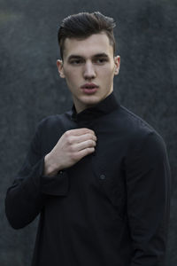 Young man standing against wall