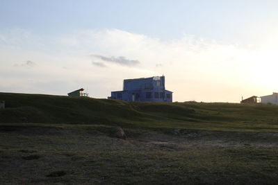 Built structure on field against sky