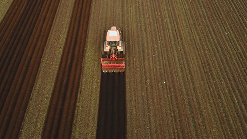 Farmer in tractor preparing land with seedbed cultivator in farmlands. tractor plows a field. 