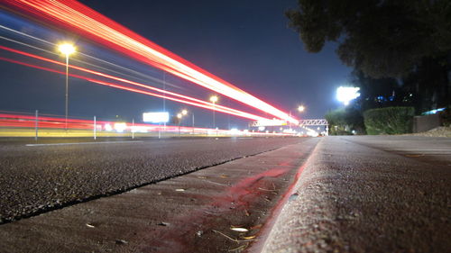 Illuminated road against sky at night