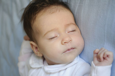 Close-up of cute baby boy sleeping on bed