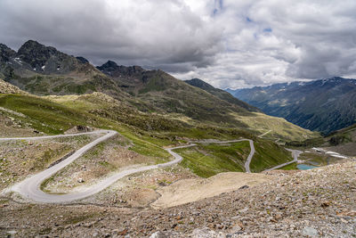 Scenic view of road by mountains against sky