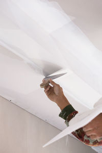 Low angle view of cropped worker plastering ceiling