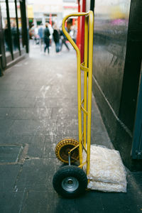 Close-up of yellow bicycle on street in city