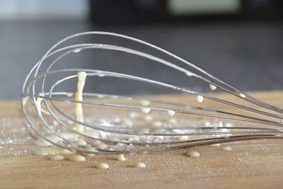 Close-up of wire whisk on table in kitchen