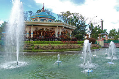 Fountain in lake against building