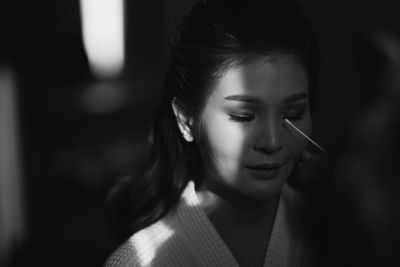 Close-up of young woman having make-up done