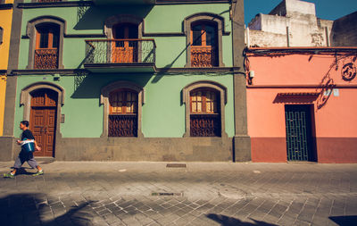 People walking on street by buildings in city