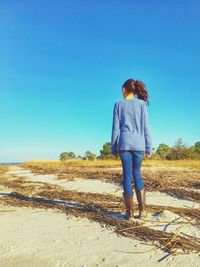 Rear view of woman standing against clear sky