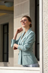 Portrait of young woman wearing sunglasses while standing outdoors