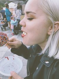 Side view of young woman eating dessert outdoors