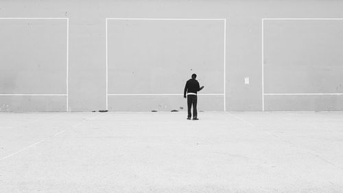 Full length of man standing against wall