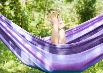 Midsection of woman lying on hammock