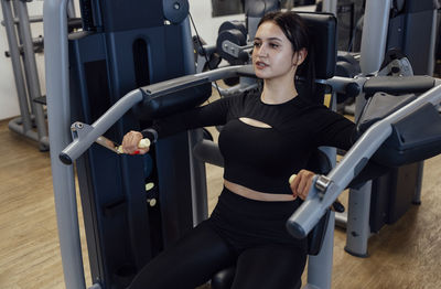 Portrait of young woman exercising in gym