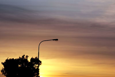 Low angle view of silhouette street light against sky at sunset