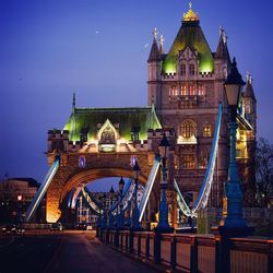 Illuminated tower bridge against sky at dusk