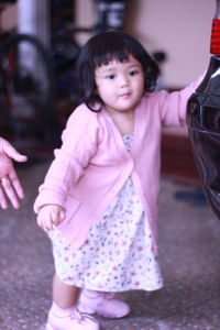Cute girl standing on pink indoors