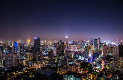 Illuminated cityscape against sky at night