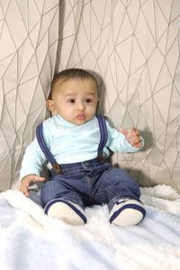 Cute boy sitting on bed