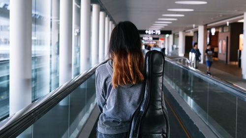 Rear view of woman standing on railing