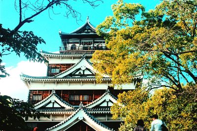 Low angle view of building and trees against sky