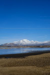 Scenic view of beach against clear blue sky