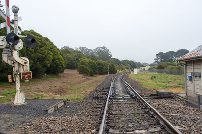 Railroad track amidst trees against clear sky