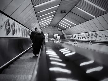 Rear view of people on escalator