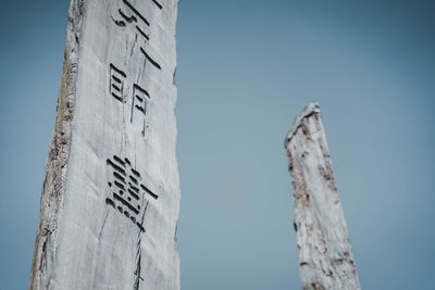 Low angle view of information sign against clear blue sky